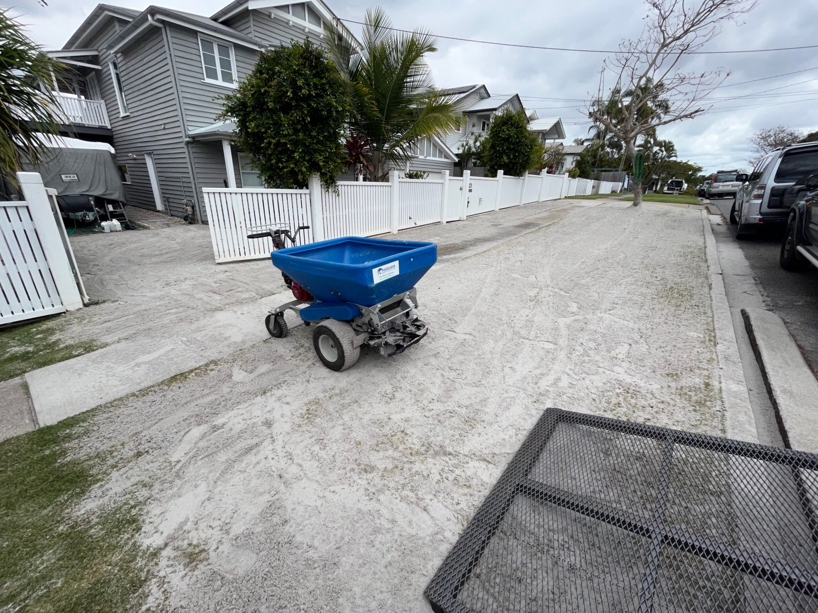 Top dressing being spread evenly across a residential street lawn